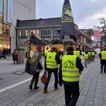 Kieler Gelbwesten von hinten gesehen, wie sie die Holstenstraße längsgehen.